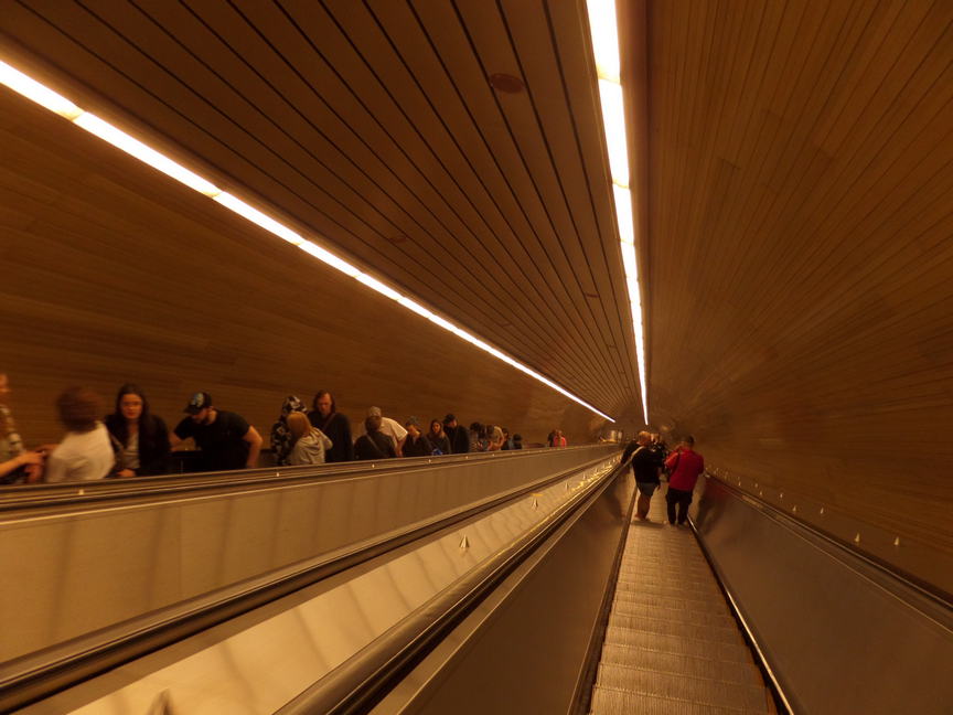 looking down an extremely long tunnel with escalator