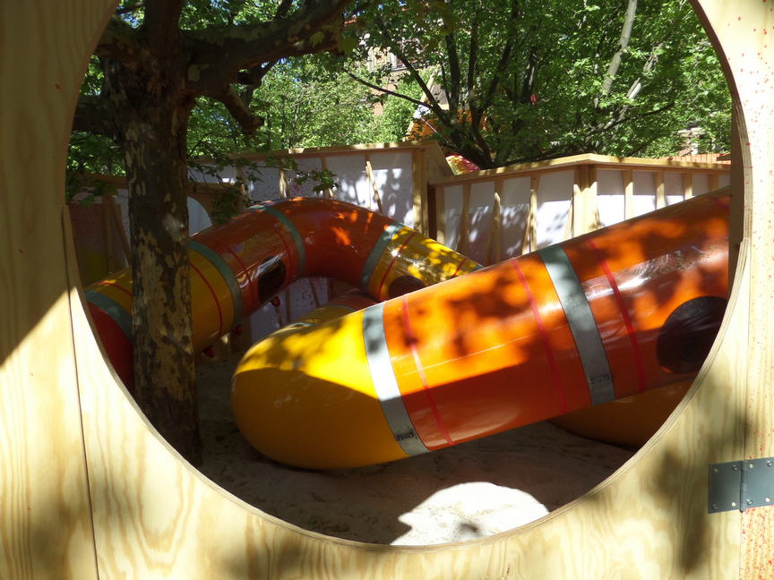 tubes with kids inside viewed through a wooden circle