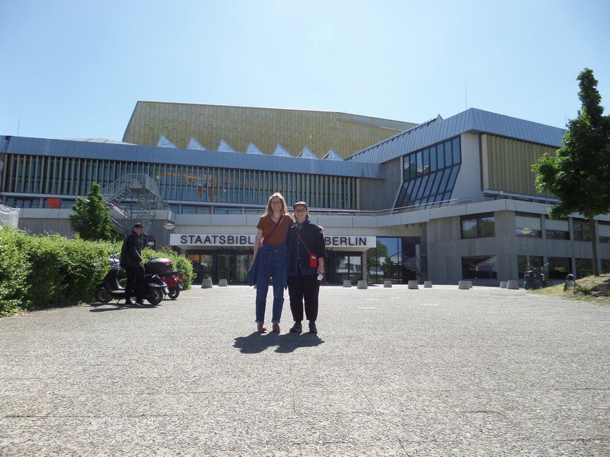 two beautiful people pose in front of berlin's staatsbibliotek