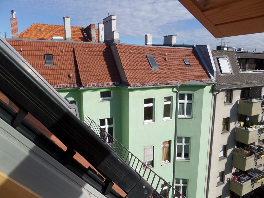 view out a top window of an apartment building to an adjacent apartment building