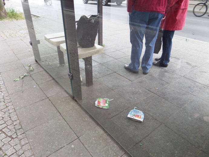 two flattened juiceboxes in a bus stop.