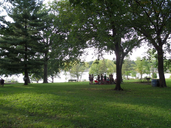 bunch of queers in the distance, green grass and sunlight