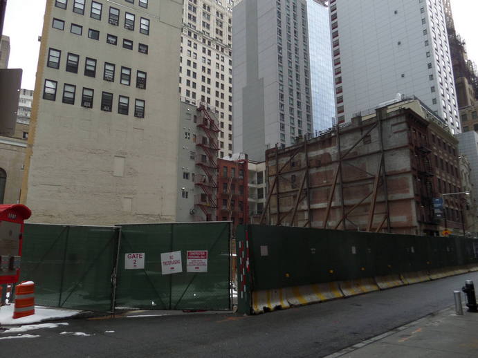 an empty city lot under construction surrounded by highrises