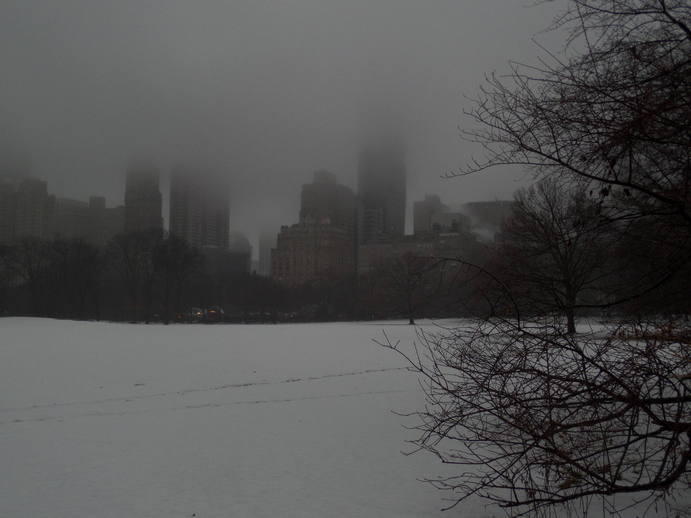 foggy skyscrapers across a snowy field.