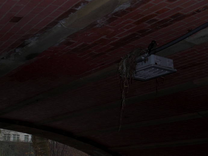 square light on the underside of a tunnel opening, unlit.