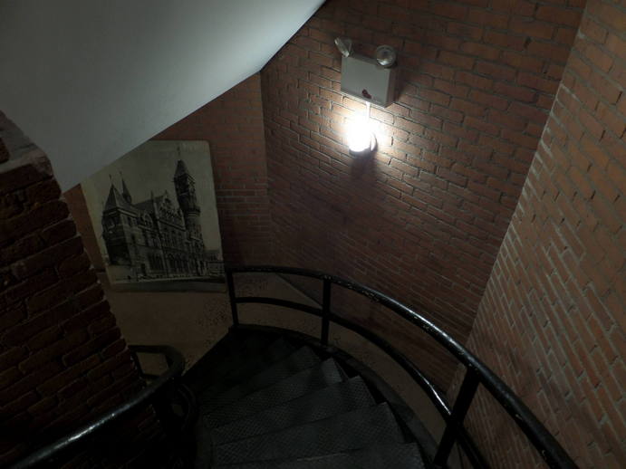 big photo of a church converted to a library leaning against a wall at the base of a spiral staircase.