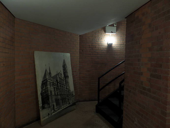 big photo of a church converted to a library leaning against a wall at the base of a spiral staircase.