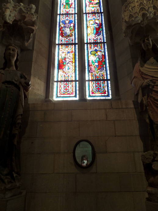 stained glass and a small oval mirror with the words 