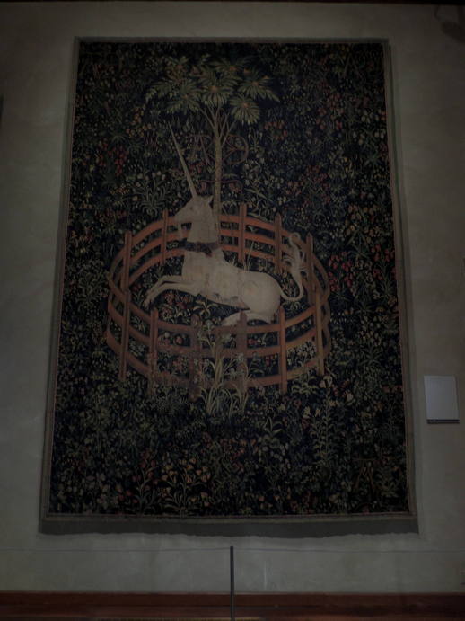 a tapestry of a unicorn chained in a small circular fence