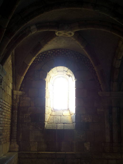 bright light coming through an arched stone window.