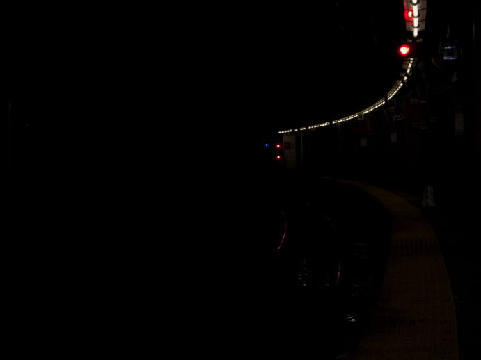 curved subway platform, dark.