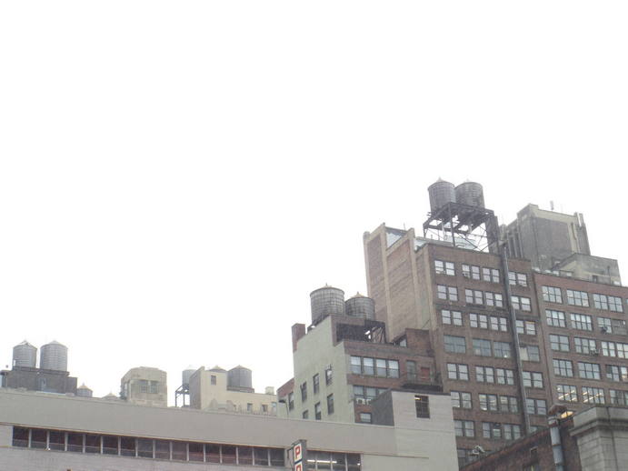 bright white sky, water towers on top of highrises.