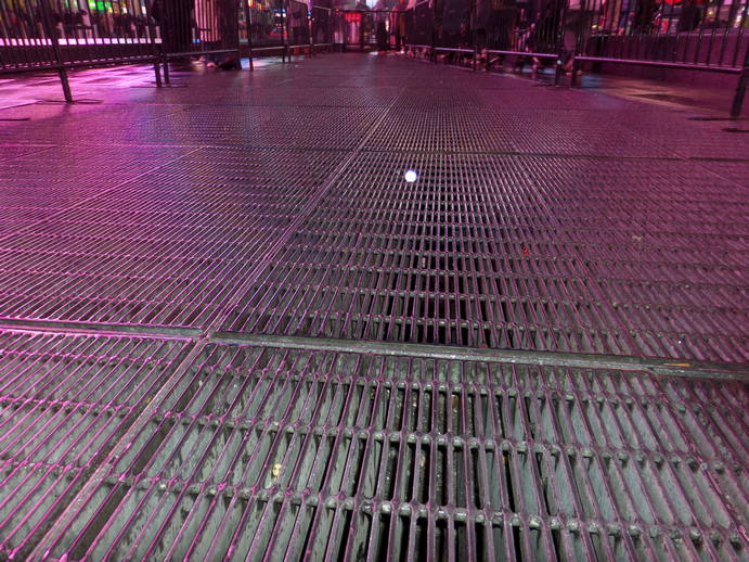 flash photo of a long expanse of thick grates. 