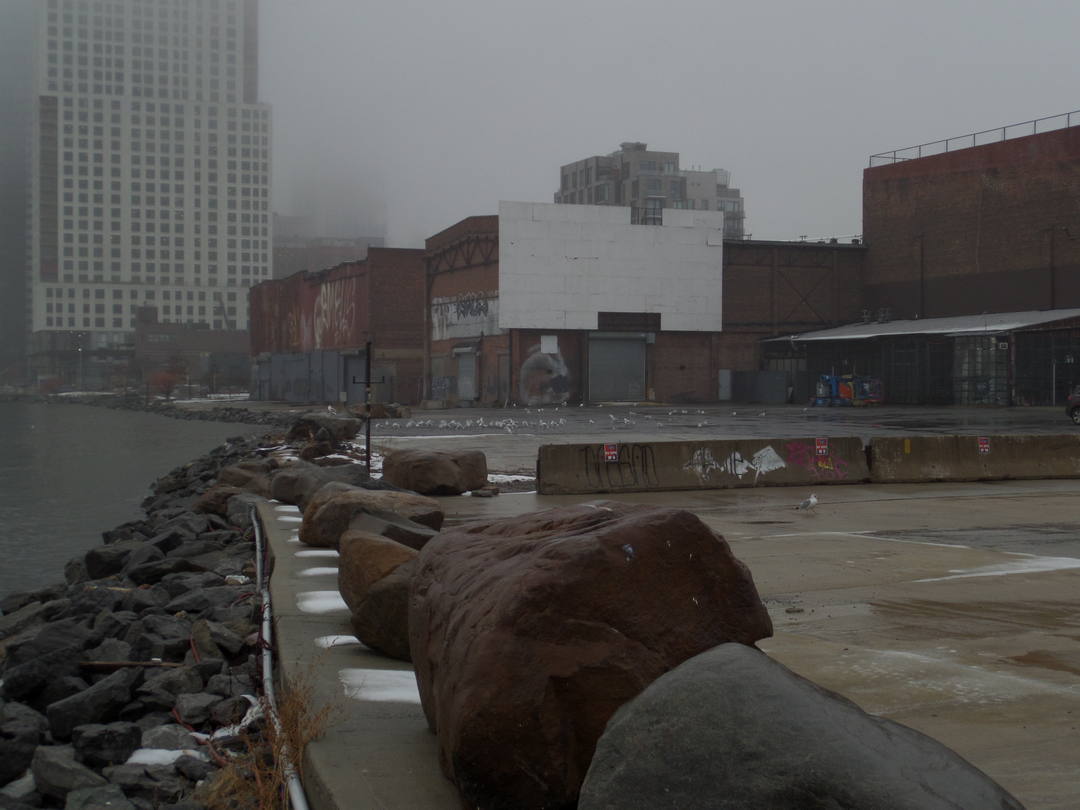 buildings at the edge of the foggy rocky waterfront