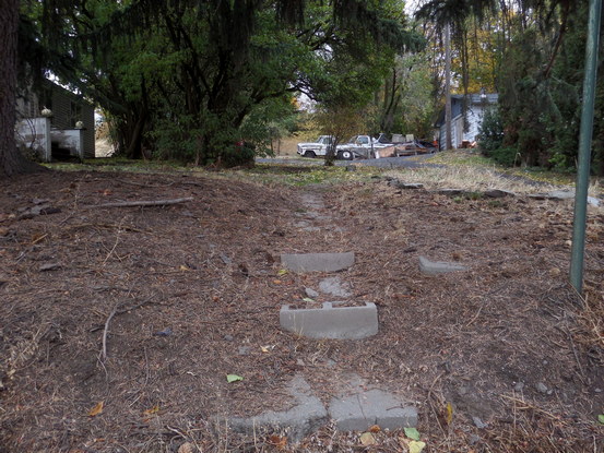 cinderblock steps to a dirt path leading up to a covered doorway.