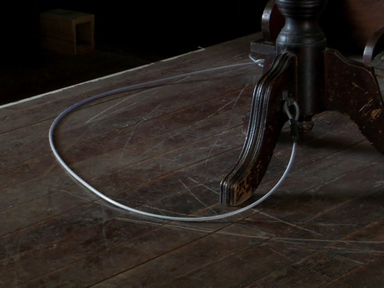 a scratched wooden floor; a stool tied to the organ.